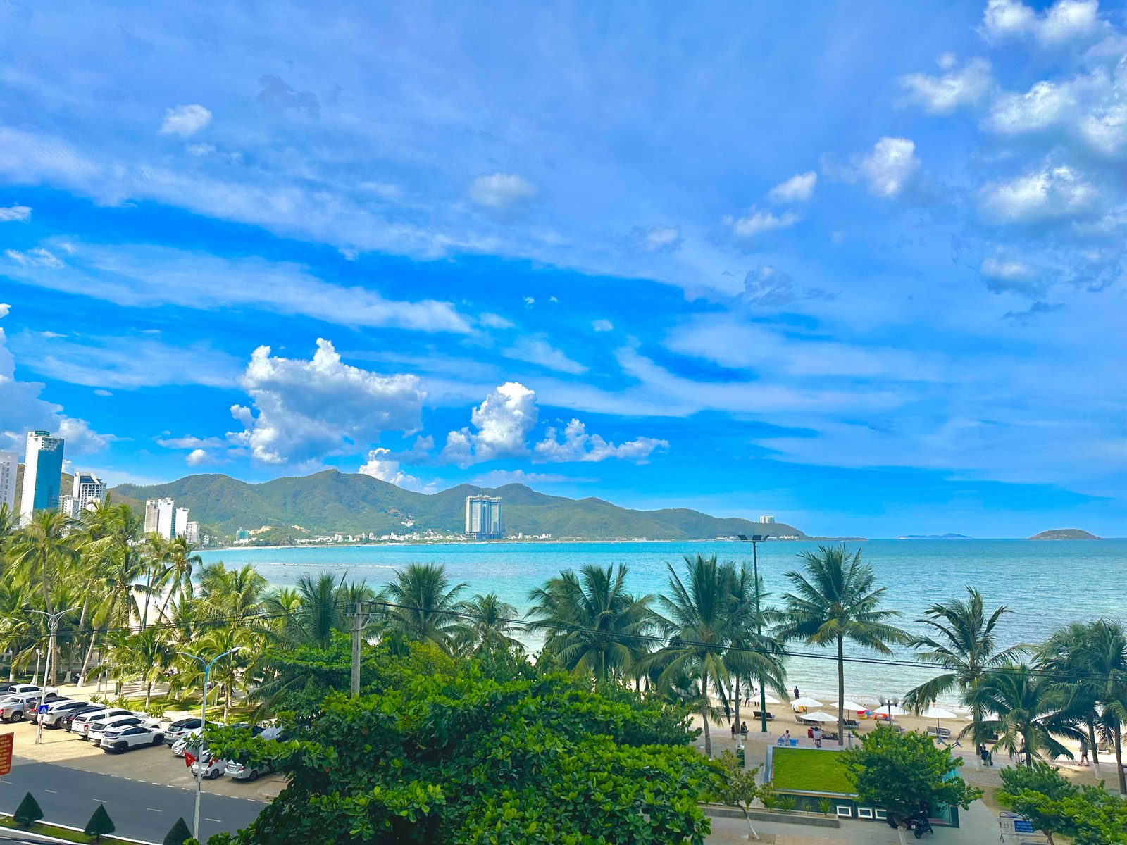 View biển Nha Trang nhìn từ tầng cao căn hộ — bãi biển, hàng dừa và vịnh xanh
