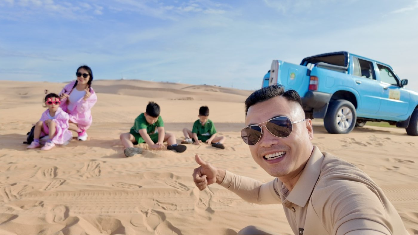 Khuất Anh Dũng cùng vợ và ba con trong một chuyến đi chơi trên đồi cát
