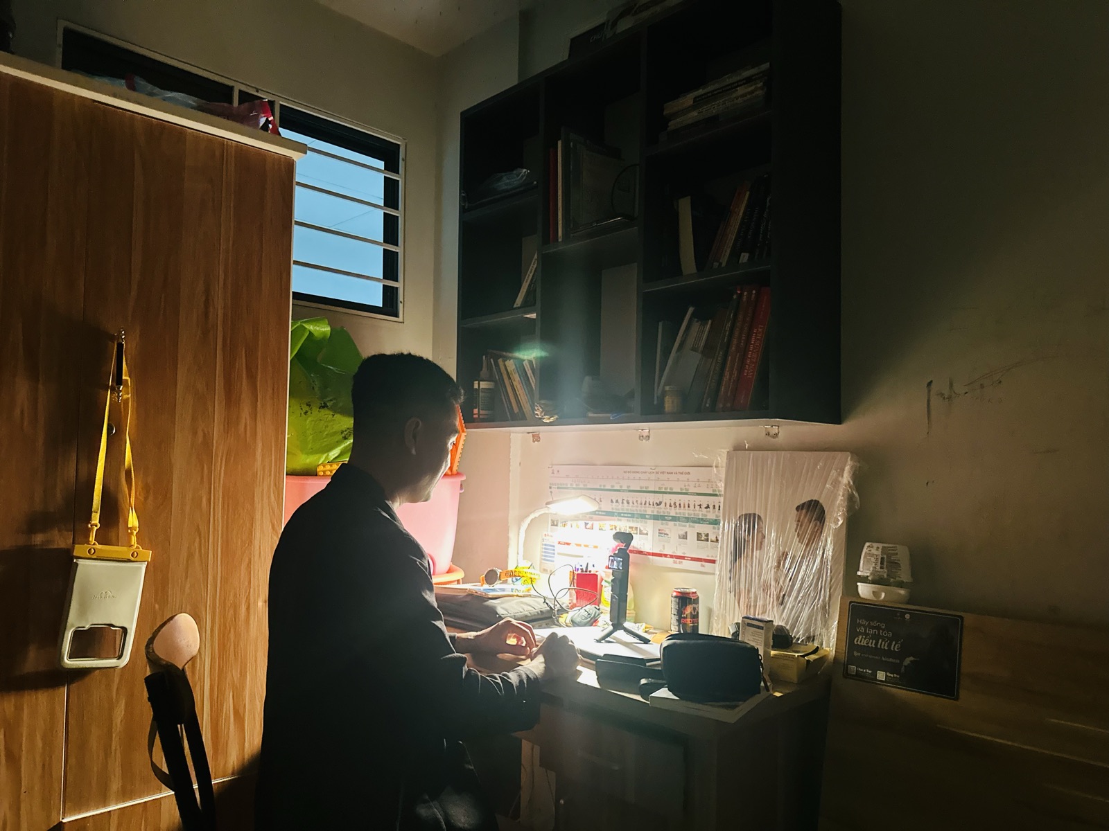 Khuất Anh Dũng đang quay video buổi tối tại góc bàn làm việc